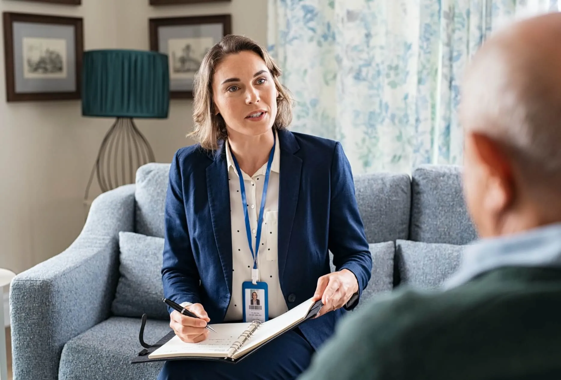 Case worker sitting on couch talking to patient