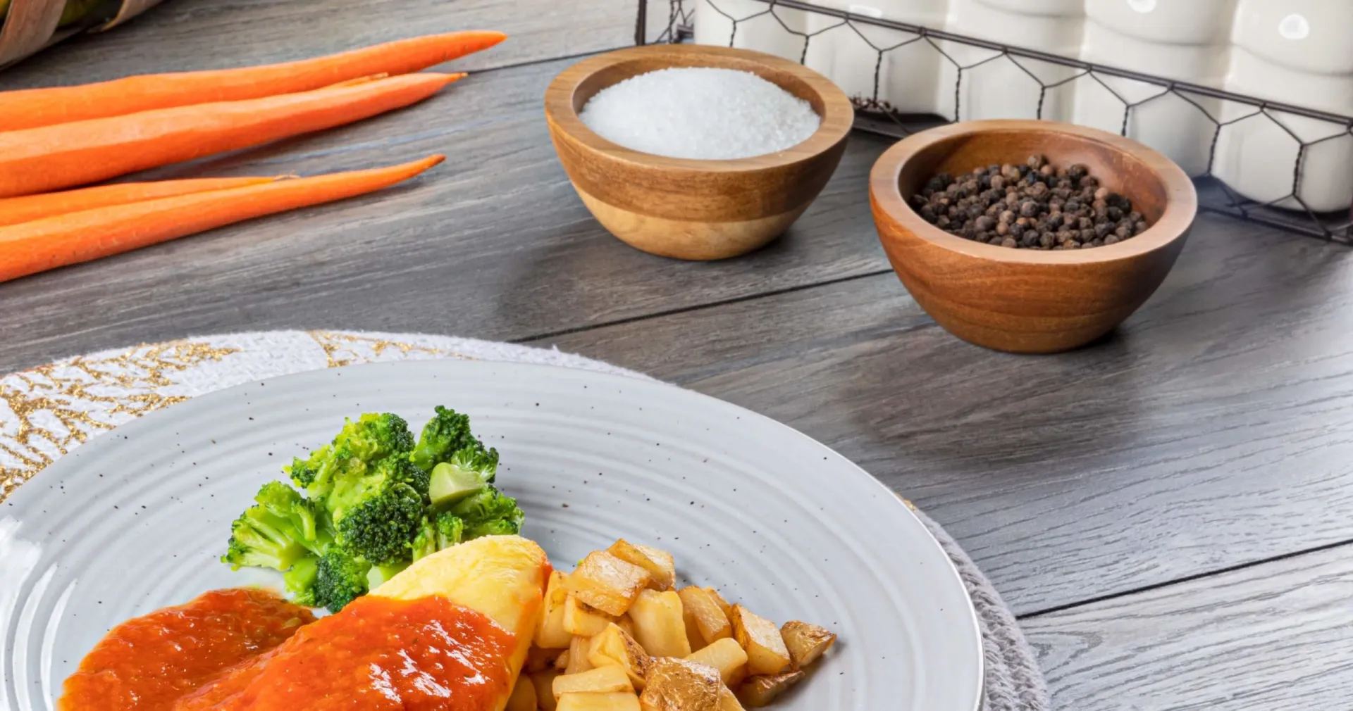 Breaded chicken with marinara, roasted potatoes and broccoli on plate. 