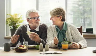 A couple eating a meal together happily
