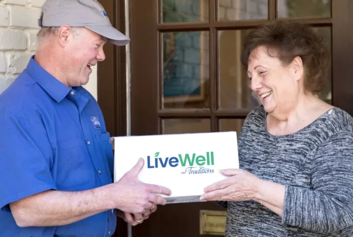 Woman receiving a deliver of LiveWell with Traditions