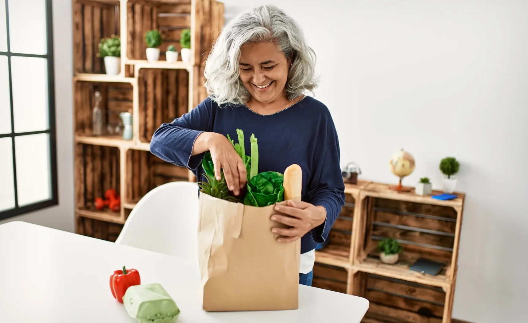 a woman taking out groceries from a paper bag
