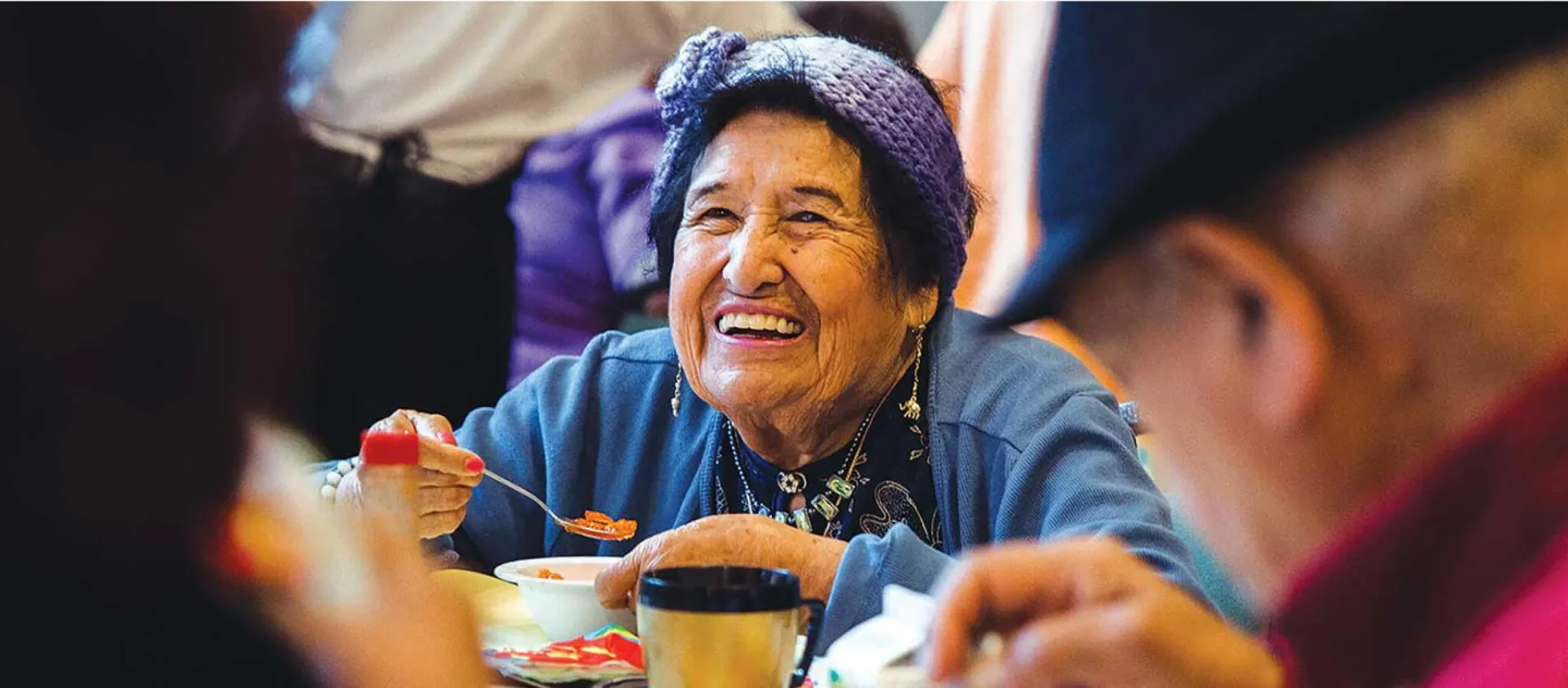 A senior lady eating and smiling