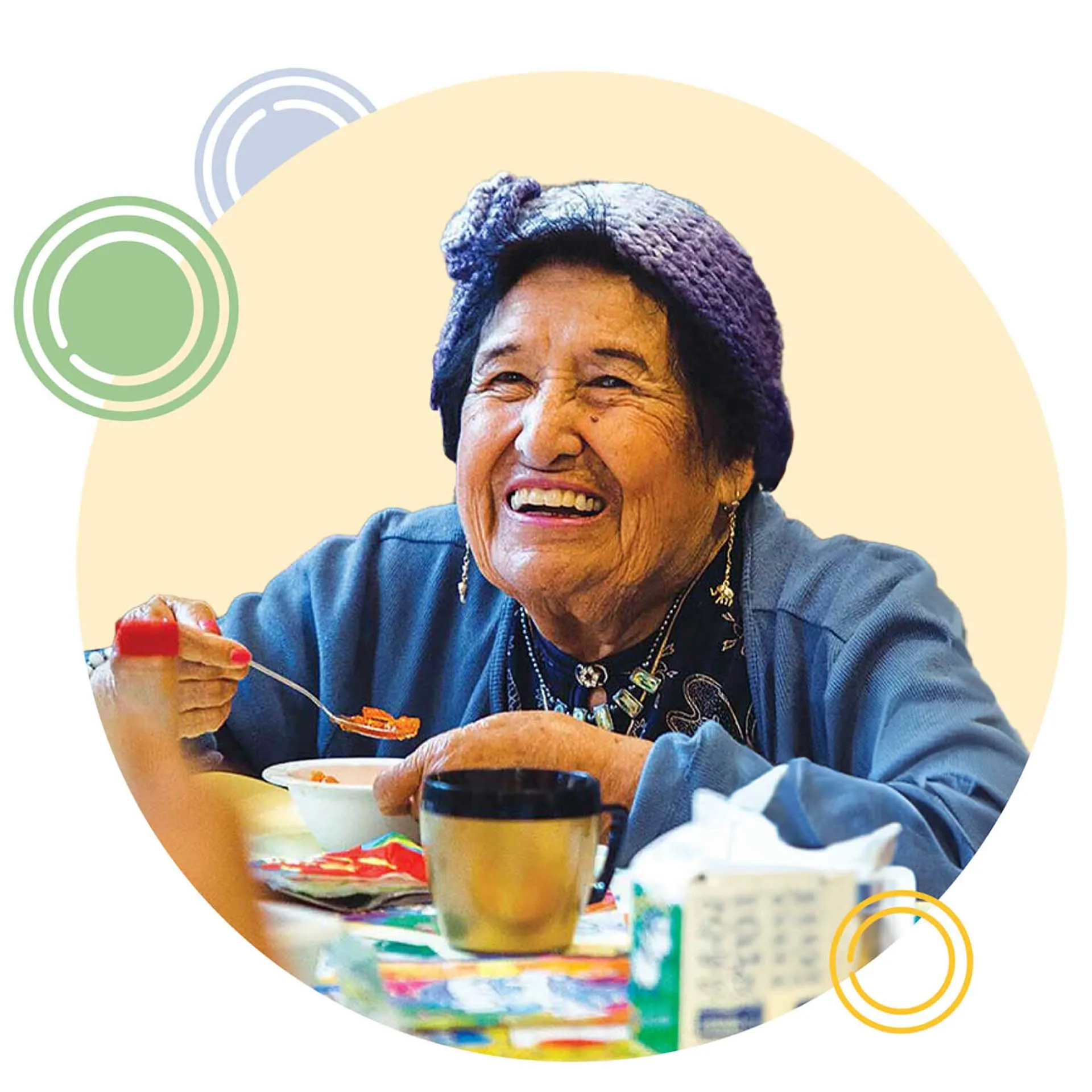 Smiling elderly woman sitting at table enjoying a meal