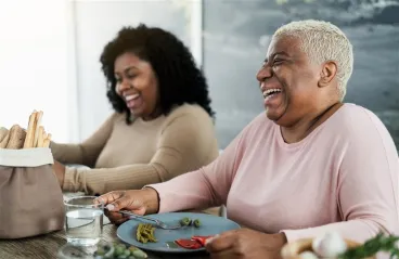 two women eating and laughing