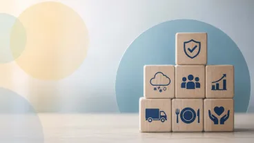 Wooden blocks with icons representing meal delivery, nutrition, community support, safety, and growth.