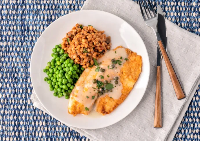 Overhead view of fish filet with peas and rice