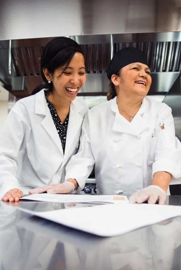 Traditions Meals employees laughing in kitchen