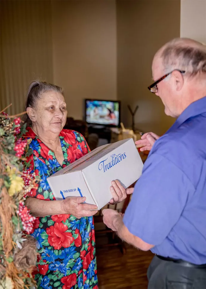 Woman receiving delivery of Traditions meals from driver