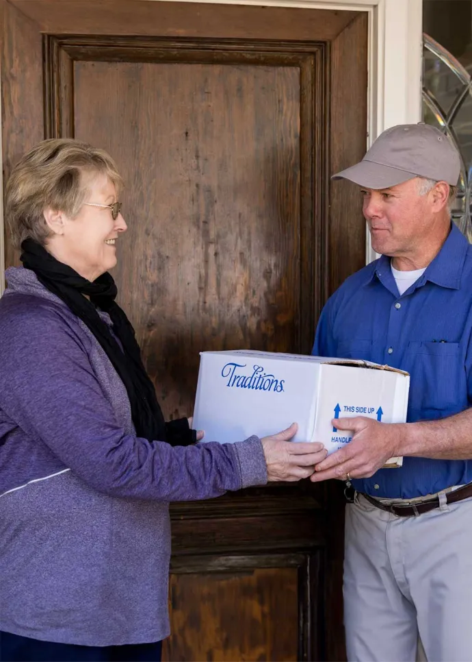 Woman receiving a Traditions delivery from driver