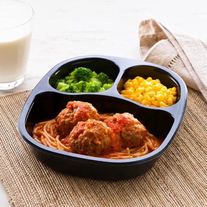 Spaghetti and meatballs, corn and broccoli in a microwavable container