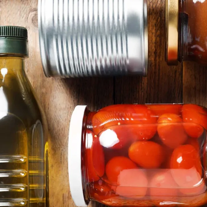 assorted non-perishable items in jars, cans and bottles on wood tabletop